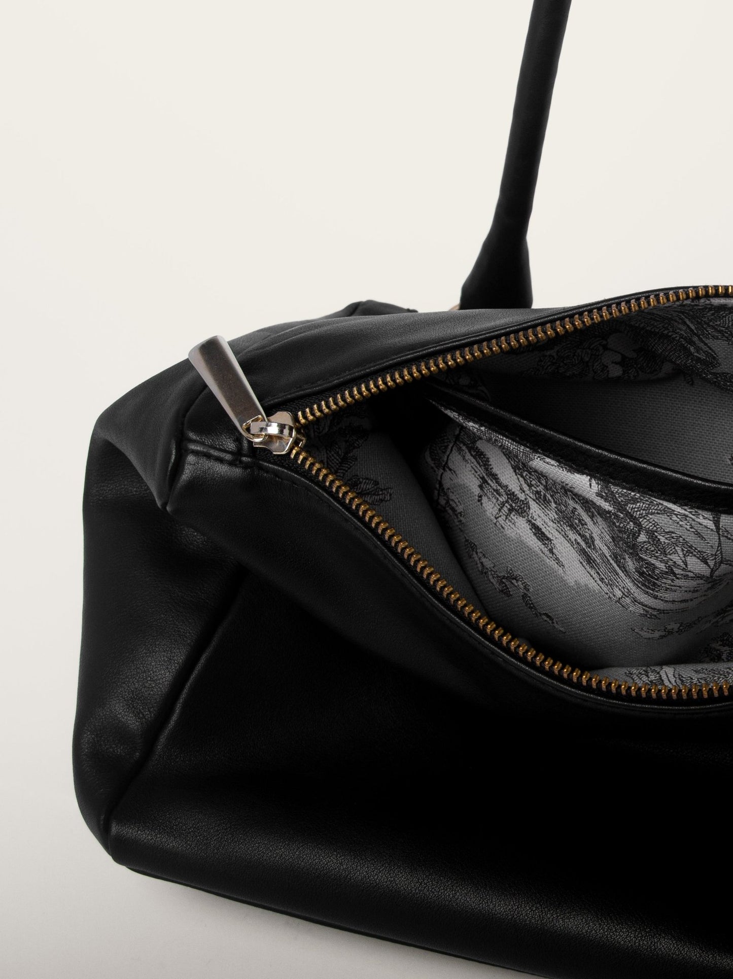 Detalle interior del bolso estructurado negro Bess Madrid con compartimentos y forro estampado