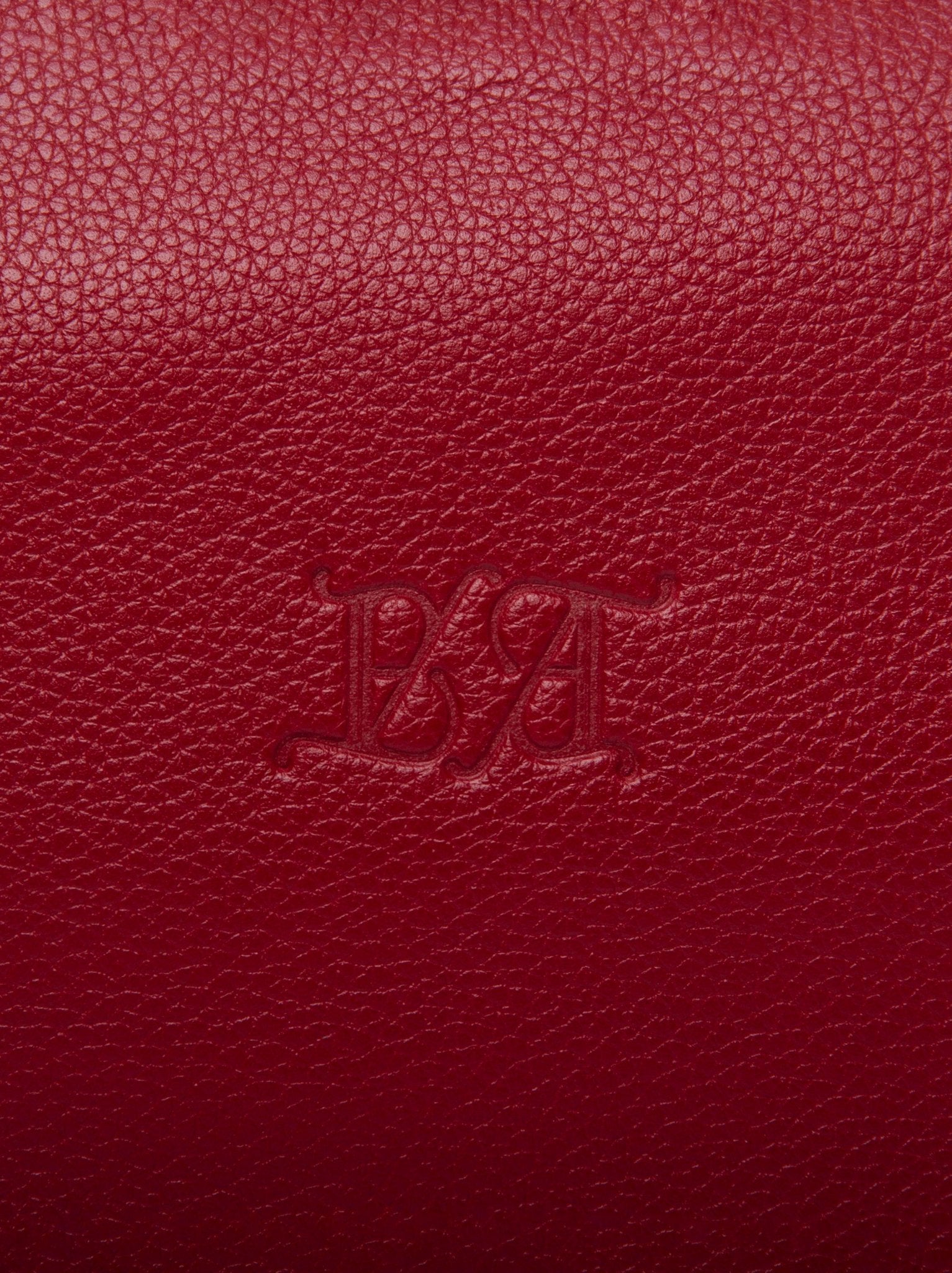 Detalle del logo timbrado sobre piel de vacuno guinda Bess Madrid